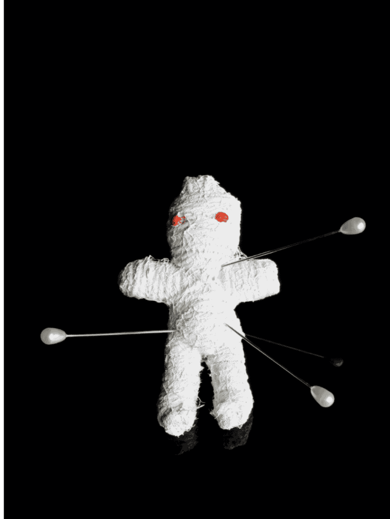 Toy doll with pins and red eyes on black background, symbolic of brand protection.