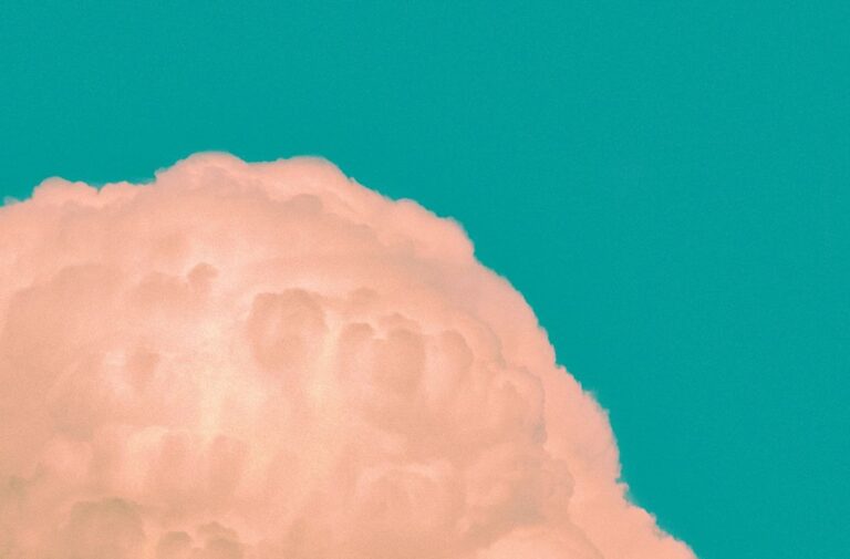 Cloud formation with a vibrant teal background.